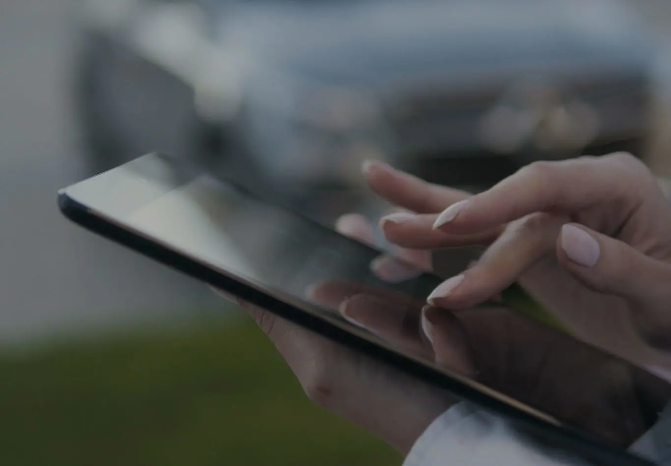 A pair of hands are interacting and holding a tablet. 