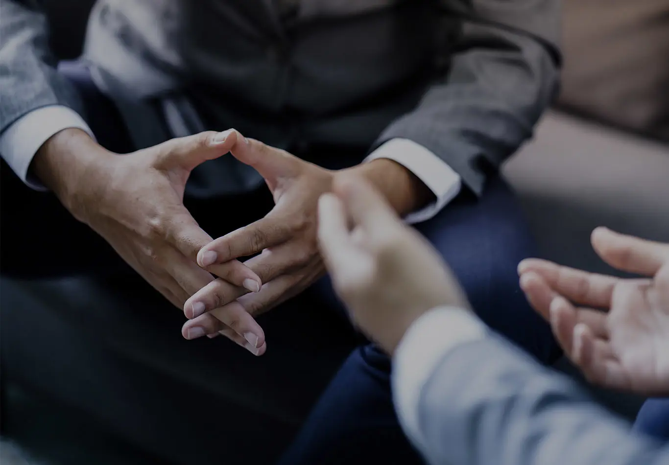 There are two pairs of hands. One pair is open and and another pair is interlocked. 