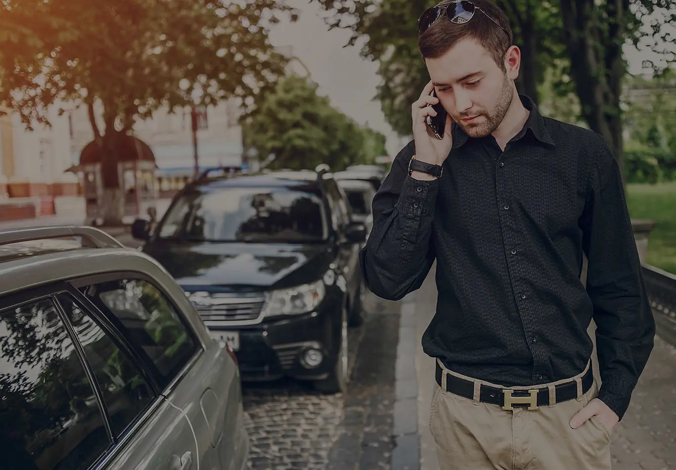A man is walking down the street and talking on the phone