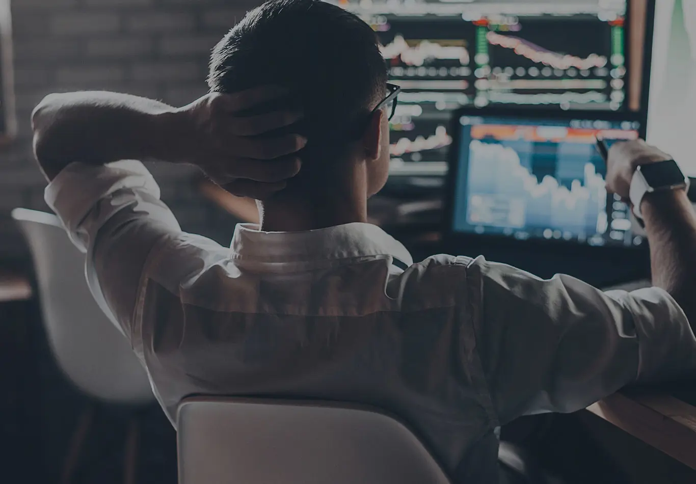 A business person is looking at a series of a monitors 