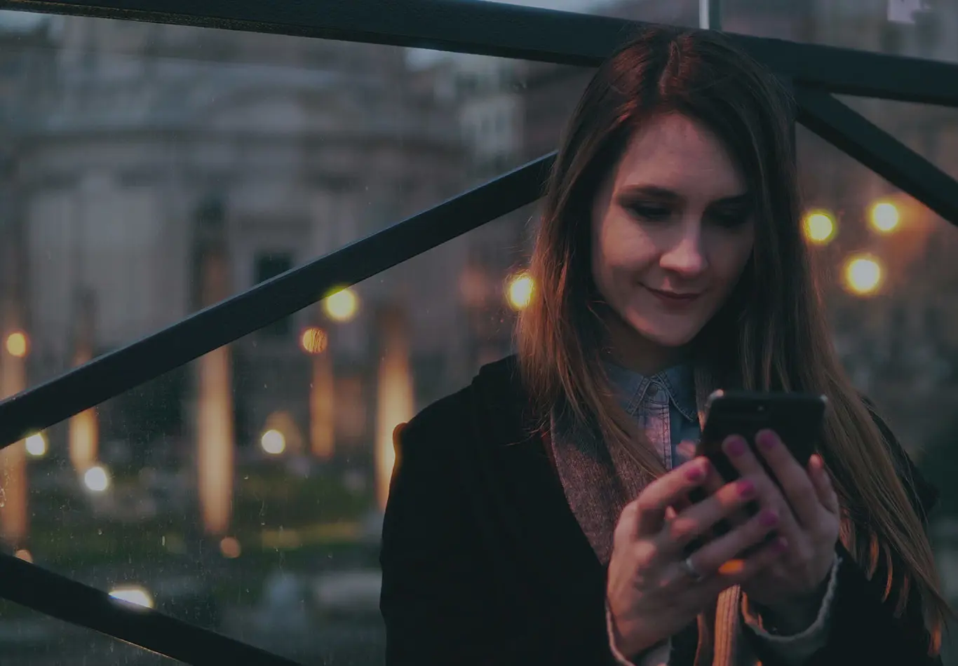 A business woman is looking at her phone outside 